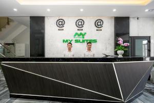 a lobby with a black counter with a poster on the wall at My Suites Danang Beach in Danang
