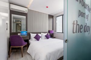 a bedroom with a bed and a desk with a laptop at My Suites Danang Beach in Danang +55 photos
