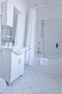 een witte badkamer met een wastafel en een douche bij Hotel Siru in Brussel