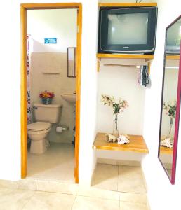 uma casa de banho com WC e uma televisão na parede em CasaHotelMarly em Santa Marta