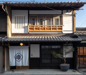 a house with a balcony on top of it at Gion Shirakawa Kouki Machiya House in Kyoto