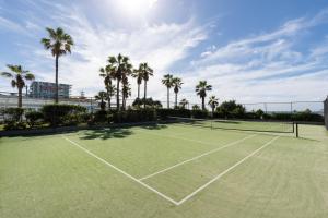 a tennis court with palm trees in the background at 19th Avenue on the Beach in Gold Coast