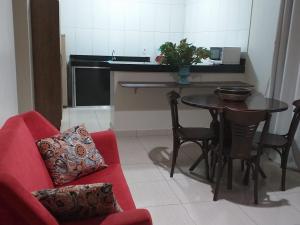 a living room with a red couch and a table at CALDAS NOVAS RESIDENCE - Inclui um ingresso por pessoa em Parque Aquático e temos HOT PARK a preço promocional in Caldas Novas