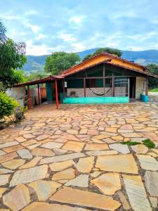 uma casa com um grande pátio de pedra em frente em Sitio Vale das Montanhas em São Tomé das Letras