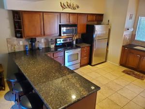 a kitchen with a granite counter top and a refrigerator at Red Rock Luxury in Sedona
