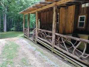 a cabin in the woods with a porch at Arrowmont Stables & Cabins in Cullowhee
