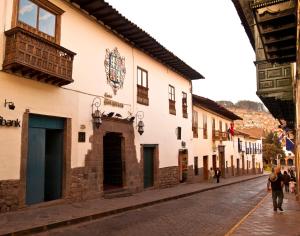 a street in a town with people walking down the street at Hotel Marqueses in Cusco