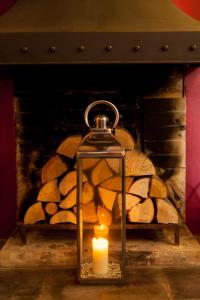 a candle in a glass jar in front of a fireplace at The Wychwood Inn in Shipton under Wychwood