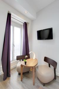 巴黎的住宿－阿朗布拉酒店，客厅配有桌子和椅子