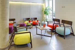 a living room filled with chairs and tables at Hotel Alhambra in Paris