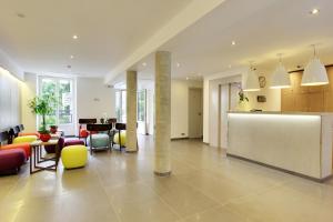 a lobby with colorful chairs and a counter in a building at Hotel Alhambra in Paris
