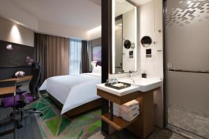 a hotel room with a bed and a sink and a mirror at Hampton by Hilton Yixing Renmin Middle Road Branch in Yixing +28 photos