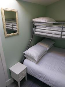 a bedroom with two bunk beds and a mirror at The Treehouse by Airlie in Nairn