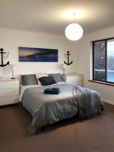 a bedroom with a large bed and a large window at The Castle - Goolwa Beach in Goolwa South