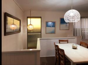 a dining room with a table and chairs and lights at The Castle - Goolwa Beach in Goolwa South