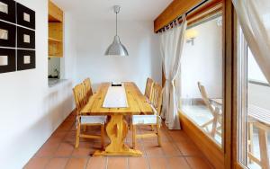 uma sala de jantar com uma mesa de madeira e cadeiras em Maurus A3 em St. Moritz