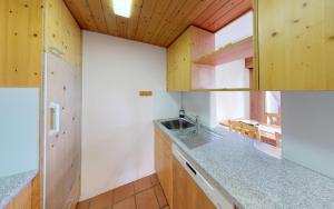 a kitchen with wooden cabinets and a sink at Maurus A3 in St. Moritz