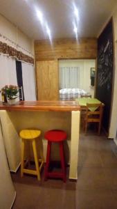 una cocina con una barra con dos taburetes en Loft Aconchegante en São Bento do Sapucaí
