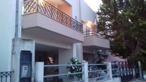 een groot huis met een balkon en een hek bij Seaside studio for 3 people - Alykes beach in Dhimínion