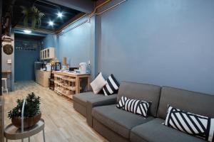 a living room with a couch and a table at Private Stay Hostel in Bangkok