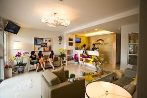 un grupo de personas sentadas en una sala de estar en Sunshine Inn Plus, en Melaka