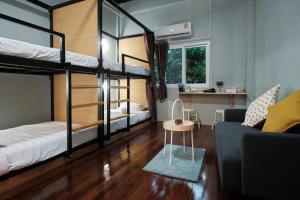 a room with two bunk beds and a couch at Private Stay Hostel in Bangkok