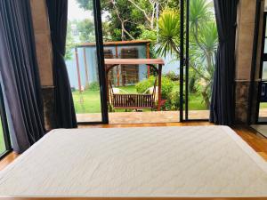 a bed in a room with a large window at The Stay Villa Pleiku in Pleiku