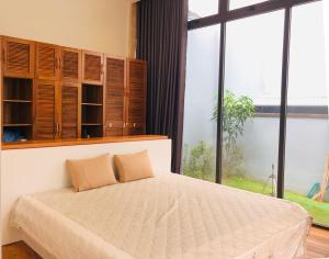 1 dormitorio con 1 cama y ventana grande en The Stay Home Pleiku, en Pleiku