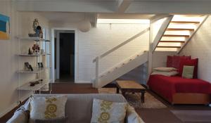 a living room with a couch and a staircase at The Castle - Goolwa Beach in Goolwa South