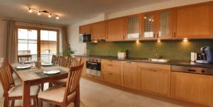 a kitchen with wooden cabinets and a wooden table with a dining room at Ferienhaus Klocker in Ried im Zillertal