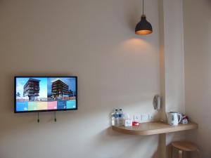 una TV a schermo piatto appesa a un muro di The City Hotel a Ambon