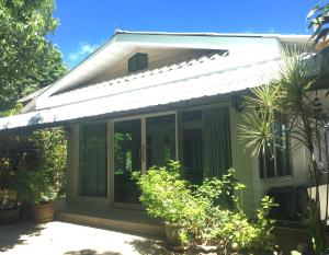 a green house with sliding glass doors at Casa Bonita Kanchanaburi in Kanchanaburi