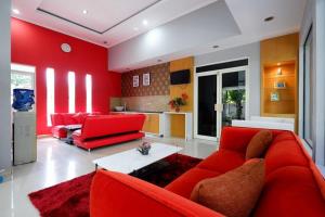 uma sala de estar com mobiliário vermelho e uma parede vermelha em RedDoorz near Solo Square 3 em Bonorejo