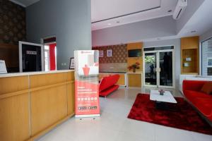a living room with a red couch and a table at RedDoorz near Solo Square 3 in Bonorejo