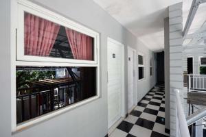 um corredor com uma janela e um piso xadrez em RedDoorz near Solo Square 3 em Bonorejo