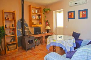 ein Wohnzimmer mit einem Tisch und einem TV in der Unterkunft Casa La Fuente in El Gastor