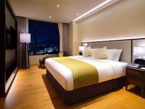 Krevet ili kreveti u jedinici u okviru objekta Grand Mercure Ambassador Hotel and Residences Seoul Yongsan