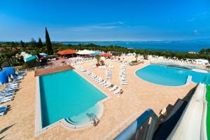 an aerial view of a resort with two pools and chairs at Camping Lido in Lazise