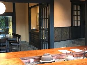 a kitchen with a wooden table and wooden chairs at Kyomachiya Ryokan Sakura Urushitei in Kyoto