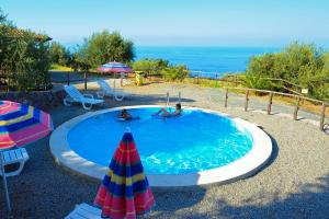 a swimming pool with two people and an umbrella at Agriturismo Santa Margherita in Gioiosa Marea