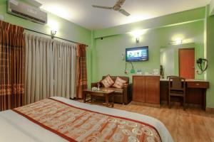 a hotel room with a bed and a living room at Hotel Peace Plaza in Pokhara
