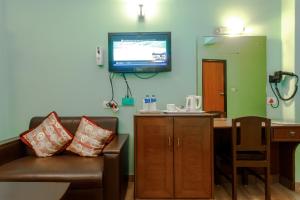 a living room with a couch and a tv on the wall at Hotel Peace Plaza in Pokhara