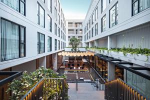 清迈Novotel Chiangmai Nimman Journeyhub的享有带桌子和植物的建筑的内部景色