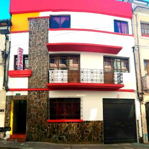 ein mehrfarbiges Gebäude in einer Stadtstraße in der Unterkunft Hostal Bavaria de la Alameda in Quito