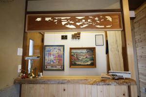 eine Theke in einem Raum mit Gemälden an der Wand in der Unterkunft Hostel Fish in a River in Takayama