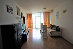 a living room with a couch and a tv at Apartments in hotel Primorsko Del Sol in Primorsko