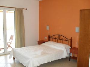 a bedroom with a bed and a balcony at Emmanouil in Kythira