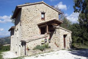 a small stone building with flowers in front of it at B&B BOSCOVECCHIO in Assisi