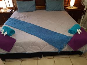 a bed with a blue blanket on it at Cassiandra Place unit 2 in Richards Bay