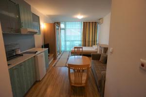 a small kitchen and a living room with a table at Apartments in hotel Primorsko Del Sol in Primorsko